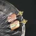 Handmade baroque pearl drop earrings featuring gold flower studs with green gemstones - Purple Emerald Clover Studs