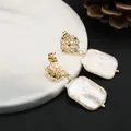 Elegant baroque pearl dangle earrings with gold filigree flower design and green stones detail - White Emerald Hollow Lace Studs