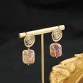 Elegant gold spiral stud earrings featuring unique square pinkish baroque pearls - Purple Lollipop Studs