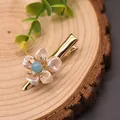 Retro gold hair clip featuring a handmade pearl flower with a light blue center - Aquamarine Pearl Flower Hair Clip