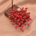 Elegant pearl brooch with cascading red beads on a wooden display stand for high-end fashion - Natural Pearl Fat Rice Brooch