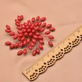 Handmade ethnic vintage red sea bamboo beaded flower brooch shown next to a ruler - Large Rice Windfire Wheel Brooch