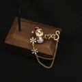 Elegante spilla natalizia in perle placcata oro 18K con motivo Babbo Natale e fiocco. - Spilla Babbo Natale / Stile Spilla