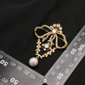 Elegante spilla a fiocco placcata oro 18 carati con perla d'acqua dolce e cristalli luce. - Stile Fiocco (Spilla di Perle Accessorio Oro)