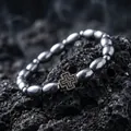 Nahaufnahme eines Herrenarmbands mit Perlen in Kaffeebohnenform und einem Vintage-Kreuz - Silbernes Kreuz-Stil (S1345-A) / Silber Kaffeebohnen Armband