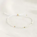 Detailopname van een boheemse kralenarmband met gouden kralen op een witte ondergrond - Transparant Wit (B-B24110503B)