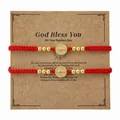 Par de pulseras tejidas rojas con medallas doradas de San Benito en tarjeta de bautizo - Juego Tarjeta Bautismo (S26070209A-P)