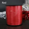 A detailed view of a 250-yard spool of glossy red ribbon for festive decorations. - Red