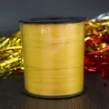 Macro view of a large roll of bright yellow smooth ribbon for party balloon decoration - Yellow