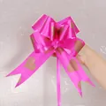 Close-up detail of a large magenta decorative pull bow featuring elegant gold heart patterns - Heart Pattern / Purple