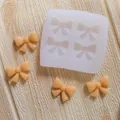 Close-up view of a bowknot silicone mold featuring four finished fondant bow shapes - 4-Cavity Small Square Bowknot