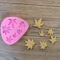 Detail view showing a pink silicone baking mold with fondant maple leaf shapes on wood - Maple Leaf