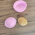 Primo piano di stampi in silicone a forma di conchiglia e una candela gialla finita. - Stampo Conchiglia Pieghevole
