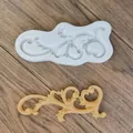 Close-up of white silicone mold and decorative resin scroll casting on wood surface. - Openwork Vintage Totem (7)
