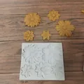 Detail view of a white flower silicone mold with molded yellow daisy fondant shapes - Five Large Flower Pattern