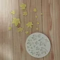 Detailed top-down view of a white silicone maple leaf mold with yellow fondant leaves - Round Multi-Maple