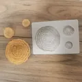 Macro detail view of white flower silicone mold and yellow soap petals on wood background - One Large And Two Small