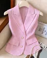 Vista dettagliata di un elegante blazer smanicato a righe bianche e rosa con bottoni perla - Taglia S / Top / Rosa