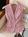 Dettaglio di un elegante gilet senza maniche a righe rosa e bianche con bottoni di perla - Taglia S / Top / Rosa