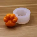 Primer plano de molde de silicona de pata de gato junto con un producto terminado naranja - Molde Pata de Gato