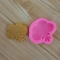 Macro detail of a pink silicone cloud mold alongside its finished smiling cloud figure - Cloud Bow