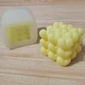 Detailed side-by-side view of a 3D heart cube silicone mold and a yellow wax candle - Medium Heart