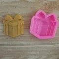 Macro detail of a pink gift box silicone mold alongside a finished yellow craft piece - Gift Box