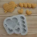Detail of heart silicone mold with molded 'TRUE LOVE' and 'LOVE' shapes on wooden surface - Love Heart