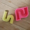 Vue détaillée d'un moule en silicone ondulé irrégulier et d'un produit en plâtre jaune - Petite Forme en S