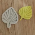 Close-up of a leaf-shaped silicone mold and its yellow resin replica on a wood texture background. - Single Leaf Small / White
