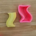 Vue de dessus de moules en silicone géométriques roses et jaunes pour bougies - Grande Forme en S