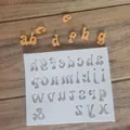 Detailed view of lowercase alphabet silicone mold with finished fondant letters on wood. - Lowercase Letters / Gray