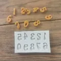 Detail view of a silicone number mold with molded orange digits on a wood background - Numbers / Gray