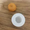 Vue de dessus d'un moule en silicone blanc en forme d'orange sur du bois - Orange Entière