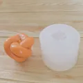 Close-up view of a knotted magic ball silicone mold alongside a finished orange candle - Knotted Sphere Style (White)