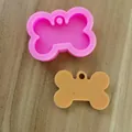 Detailansicht einer rosa Silikonform für Hundeknochen mit einem braunen Harzgussteil - Kleiner Knochen