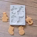 Detailweergave van siliconen vorm met sneeuwpop en kerstsok en de afgewerkte traktaties - Peperkoekmannetje