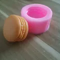 Primo piano dettagliato dello stampo in silicone macaron 3D rosa e cioccolato su legno - Forma di Macaron / Rosa