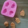 Detail view of pink silicone mold with finished cupcake-shaped fondant decorations on wood - 4-Cavity Sweet Cone