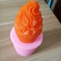Macro detail of a pink silicone cupcake mold with a vibrant orange finished craft candle. - Ice Cream Cone Shape (Bingqilin) / Pink