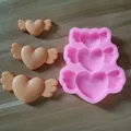 Detailed macro view of pink silicone mold with heart wing shapes and molded items - 3-Cavity