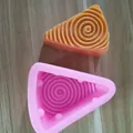 Draufsicht auf pinke Silikonform Käse und spiralförmiges fertiges Produkt in Orange - Dreiecksspirale