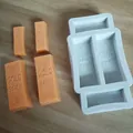 Detailed view of gold bar silicone mold with molded chocolate bars featuring 999.9 engraving - Assorted Elements