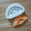 Close-up detail of classical fan shaped silicone mold and finished orange fan piece - White