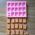 Detail view of pink silicone mahjong mold with cast orange chocolate tiles on wood surface - Thirteen Orphans