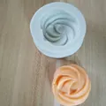 Detailansicht einer weißen Silikonform mit Wirbelmuster und orangefarbenem Gebäckstück - Einloch-Spiralmuster (Stil 3) / Stil 3