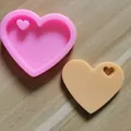 Detailweergave van een hartvormige siliconen mal en een beige hars hanger model - Mini Hartstijl