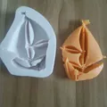 Detailed view of nautical sailboat silicone mold beside an orange fondant replica - Size 9