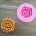 Detail view of a rose shaped pink silicone mold next to an orange wax flower sample - No. 4 (Rose Style)