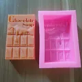 Detailed view of a pink silicone mold alongside a finished chocolate bar shaped handmade soap - Chocolate Bar Shape / Pink